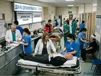 Натоварено приемно отделение в болница: лекари и сестри обслужват пациенти.