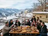 Ивановден в заснежено село с празнична трапеза и щастливи хора.